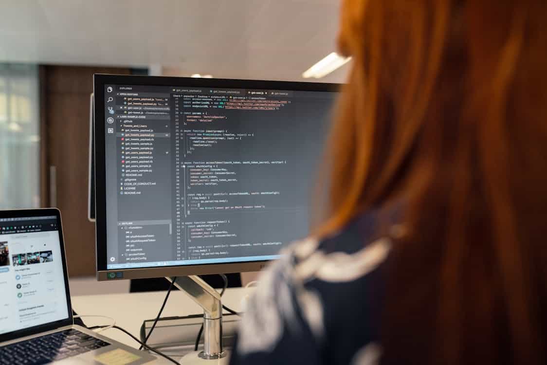 software engineer reviewing code on large screen